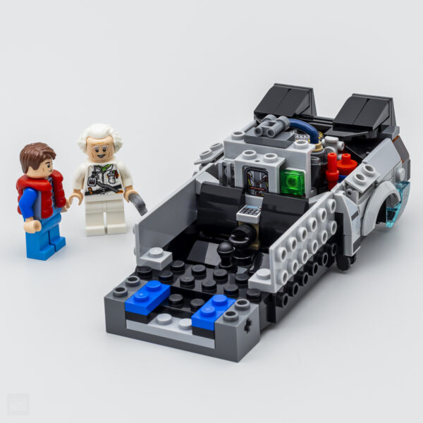 Mini voiture de science-fiction construite avec des briques LEGO, accompagnée de deux figurines de personnages de science-fiction.